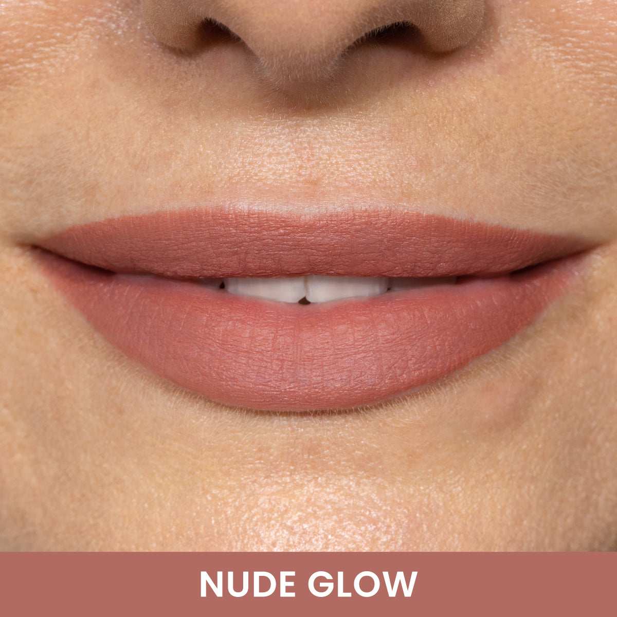 Close-up of a smiling persons lips wearing matte nude pink lipstick. Their skin is smooth, and the words NUDE GLOW appear in bold white text at the bottom on a nude-colored background.
