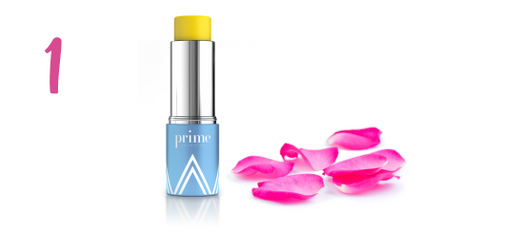 A blue and silver tube of yellow lip balm labeled prime stands upright next to scattered pink rose petals on a white background. A large pink number 1 is on the left side of the image.