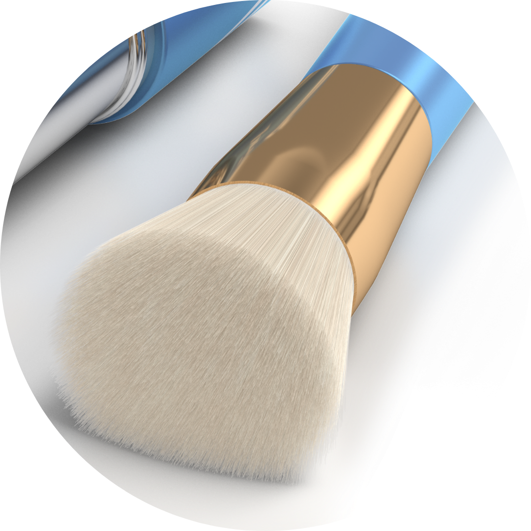 Close-up of a makeup brush with soft, white bristles, a gold ferrule, and a blue handle, lying on a light surface. Another brush is partially visible in the background.
