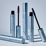 Four metallic blue tubes of PrimePrometics™ Build Your Own Bundle are shown, with two wands revealing black and brown bristles—an ideal addition to your pro-age beauty and skincare essentials routine.