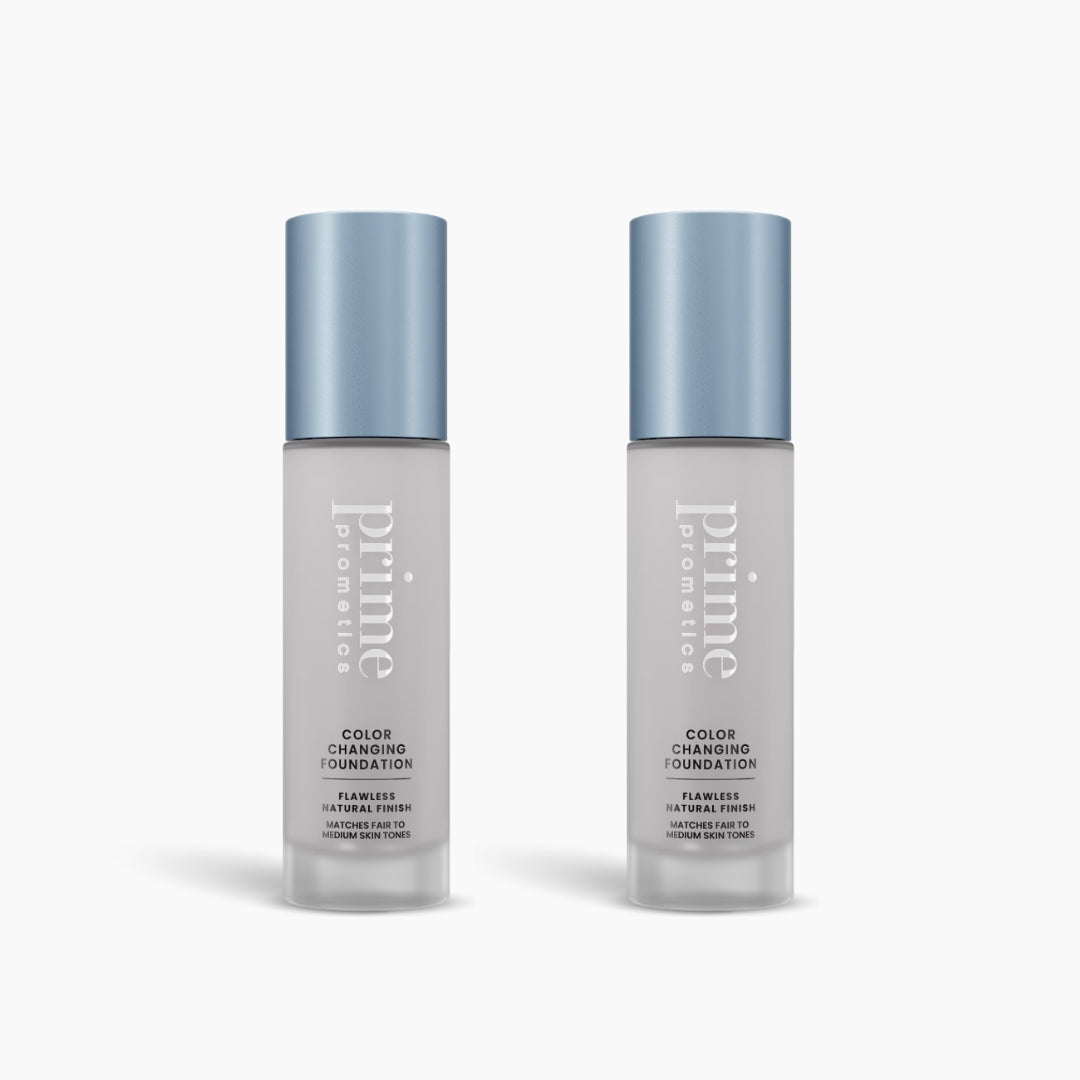 Two bottles of PrimePrometics™ 2pcs Color Changing Foundation with blue caps are shown side by side on a white background. The frosted glass bottles feature minimalist text highlighting their buildable, self-adjusting formula.
