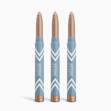 Three blue and rose gold PrimePrometics™ 3pcs PrimeEyes Eye Brightener sticks stand upright against a white background, each featuring a pointed shimmery beige tip and white chevron designs, ideal for brightening eyes or as under eye cream.