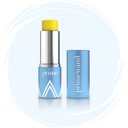 A blue cylindrical tube of skincare stick labeled prime with a yellow solid product exposed, standing next to its matching blue cap lying on its side, both displayed on a white and light blue background.