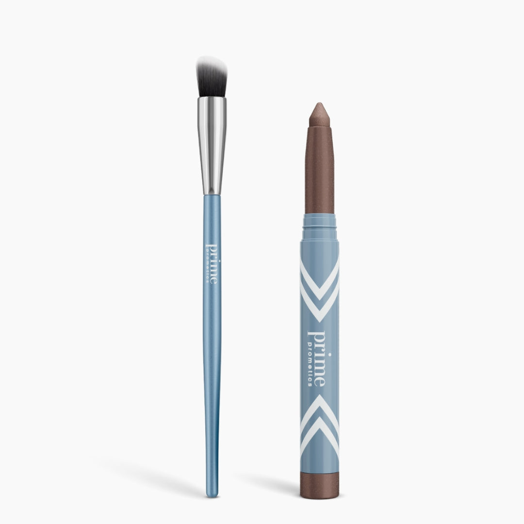 A blue PrimePrometics™ Radiance Duo Cream Eyeshadow Brush with black and white bristles sits next to a matching blue makeup stick featuring a brown Cream Eyeshadow tip, both labeled "Prime.