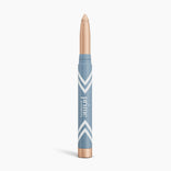 The PrimePrometics™ PrimeEyes Eye Brightener is a beige illuminating eyeshadow stick with a blue and gold tube, white chevron accents, and vertical branding—ideal for women over 50.
