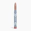 A metallic rose gold illuminating eyeshadow stick, the PrimeEyes Eye Brightener by PrimePrometics™, stands upright against a white background in its sleek blue and white tube—perfect for creating an effortless eye lift effect.