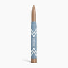 The PrimePrometics™ PrimeEyes Eye Brightener is a blue and gold makeup crayon with white chevrons and "prime promise" text, offering illuminating eyeshadow and eye lift effects for women over 50. It stands upright on a white background.