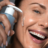Close-up of a mature woman pumping Prime Prometics Gentle Gel Cleanser, showing its clear gel texture