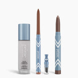 Four blue and silver PrimePrometics™ All-Day Confidence Bundle products stand upright: a color-changing foundation bottle, brown glide eyeliner pencil, small applicator vial, and thick brown eyeshadow stick.
