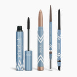 Five blue PrimePrometics™ Complete Makeover Bundle products stand upright in a row, featuring white geometric accents and silver details. Includes PrimeLash Mascara with wand, metallic eyeshadow stick, PrimeBrow Pencil with brush, and two eyeliners.