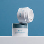 A jar of PrimePrometics™ Build Your Own Bundle PrimeEyes Hydrate Cream sits open, showcasing its white cream against a blue background—ideal for your skincare essentials or customizing your own pro-age beauty bundle.