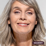 Mature woman with gray hair wearing Prime Prometics PrimeEyes Glide Eyeliner in Mulberry, a deep berry shade
