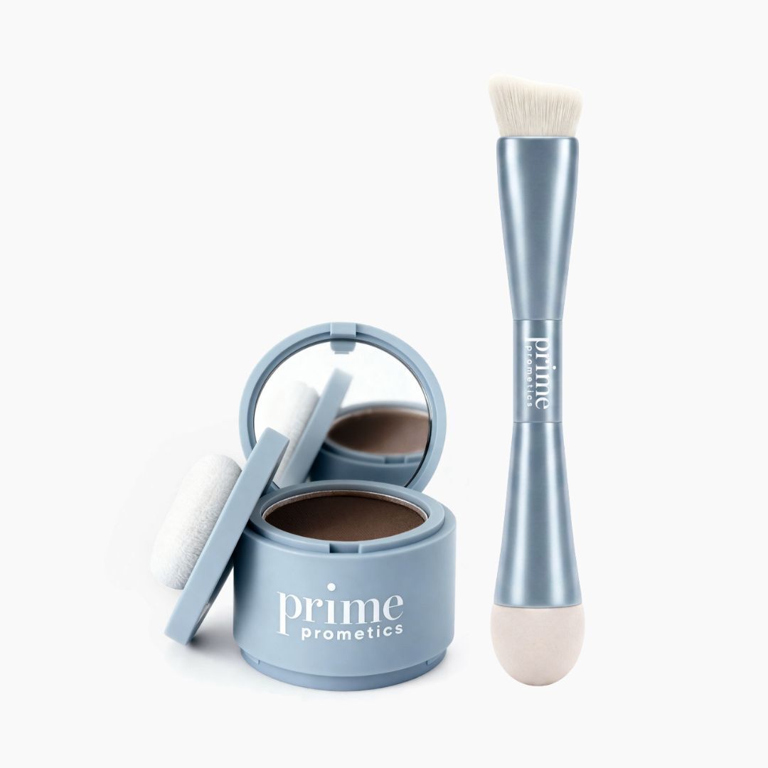 Ein geöffnetes blaues „Hairline Perfection Kit“ von PrimePrometics™ – mit integriertem Spiegel, Applikatorpolster und dem PrimePrometics™-Logo – liegt neben einem doppelseitigen blauen Pinsel, der auf der einen Seite Borsten und auf der anderen Seite eine Schwammspitze aufweist und sich ideal für das präzise Auftragen von Haaransatzpuder und die makellose Abdeckung grauer Haare eignet.