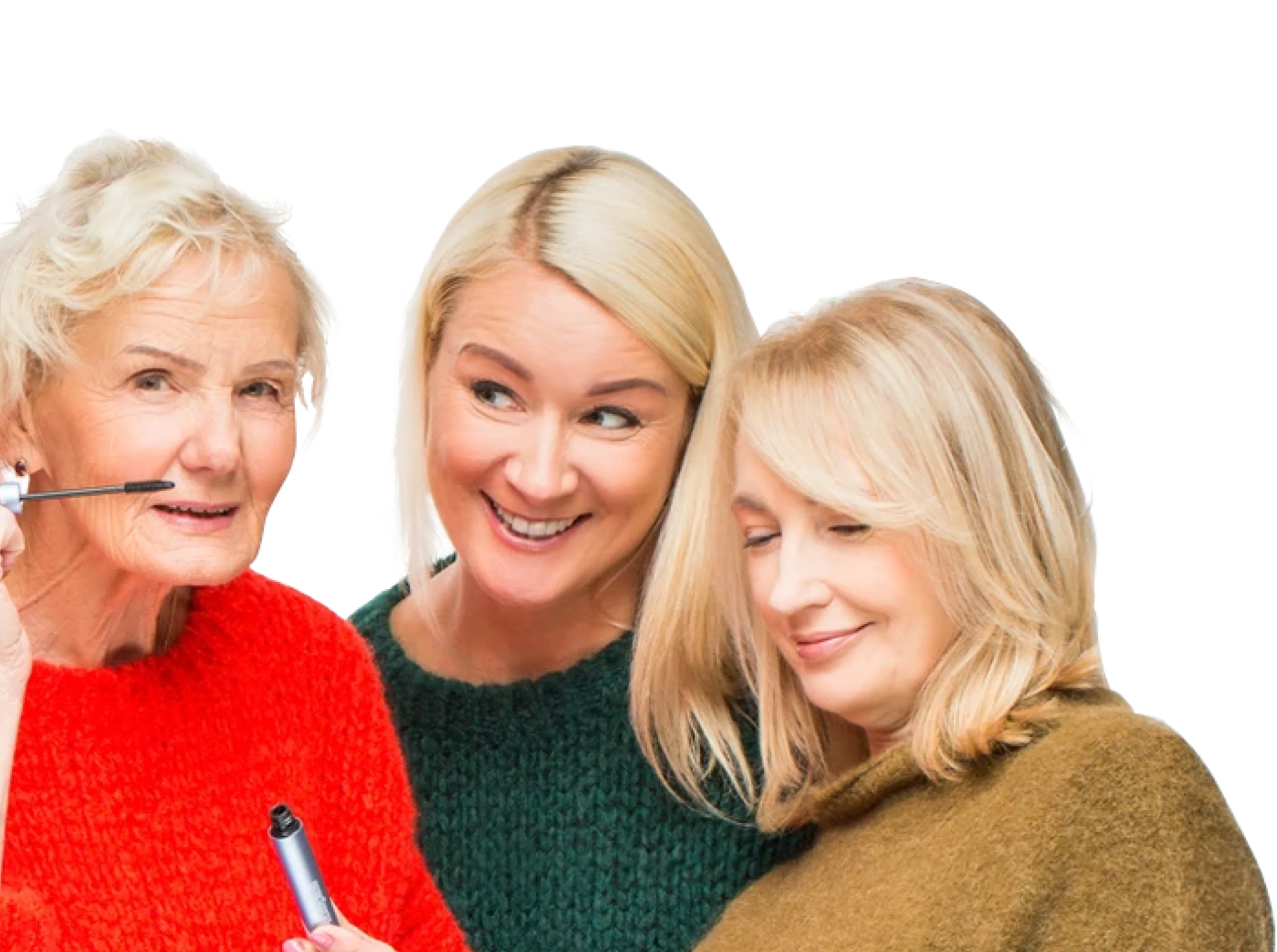 Three women wearing colorful sweaters stand together smiling. The woman on the left, in red, applies mascara, while the other two, in green and olive sweaters, smile and look supportive. The background is plain white.