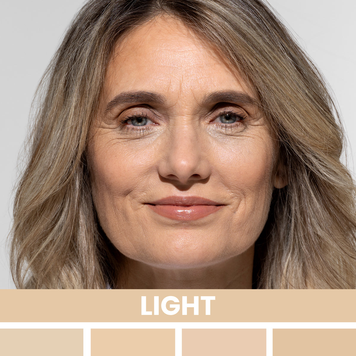 A middle-aged woman with light skin and shoulder-length ash-blonde hair smiles softly. The word LIGHT and various light skin tone swatches appear below her face.