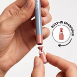 A person removes the end cap of PrimePrometics™ Velvet Lip Contour to reveal a built-in sharpener, highlighted in a circular inset with “BUILT-IN SHARPENER.” Ideal for long-lasting lipstick precision.