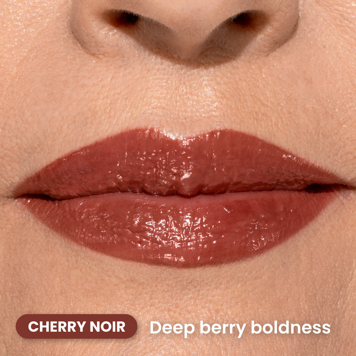 Close-up of lips wearing glossy, deep berry-colored lipstick. The text reads “CHERRY NOIR” and “Deep berry boldness” in white and dark red boxes.