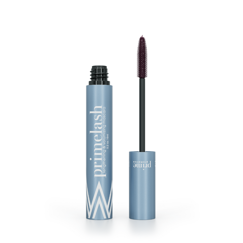 A blue tube of primelash mascara with the wand applicator displayed next to it, cap removed, revealing the brush coated with product. The tube features bold white text branding.