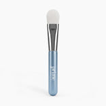 PrimePrometics™ PrimeLift Precision Applicator Brush featuring an ultra-soft white synthetic bristle head, silver ferrule, and metallic blue handle, designed to be gentle on mature skin.