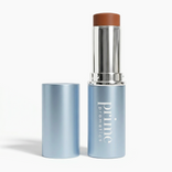 A blue tube of PrimePrometics™ PrimeWands 5-in-1 Makeup Wand, with the cap off to reveal the brown product inside, stands on a white background. This versatile multi-use wand offers buildable color for a flawless, radiant finish.