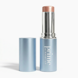 A blue tube of PrimePrometics™ PrimeWands 5-in-1 Makeup Wand with the cap removed and set beside it, revealing a shimmery beige product inside. This skincare-infused makeup stick provides buildable color for customizable coverage.