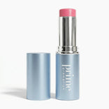 A blue tube of PrimePrometics™ PrimeWands 5-in-1 Makeup Wand with the cap removed, revealing a pink skincare-infused makeup product inside. This multi-use wand delivers buildable color for versatile looks, while the cap stands upright beside the tube.