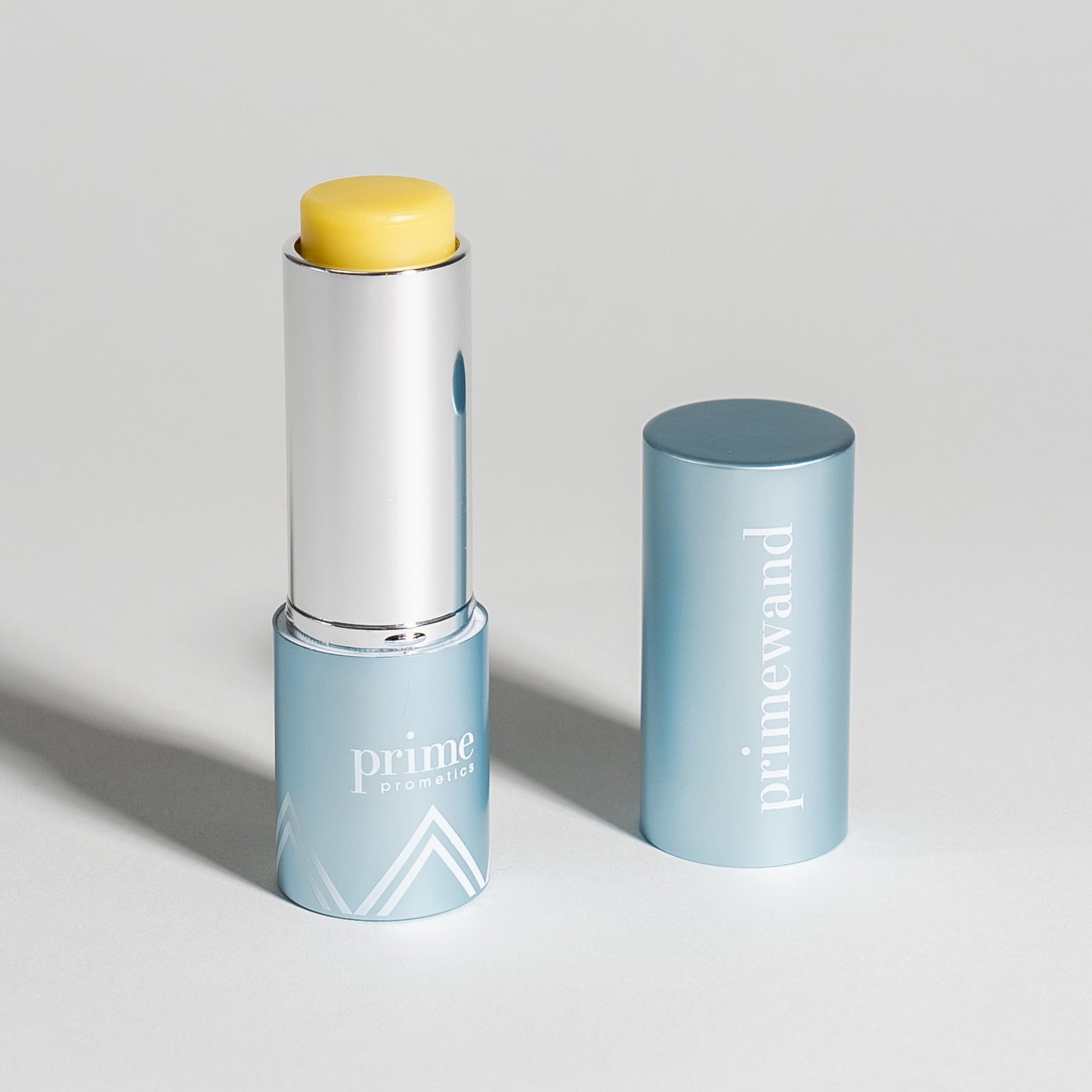 Prime Prometics PrimeWand Nourish stick moisturizer with yellow balm exposed and the blue cap beside it