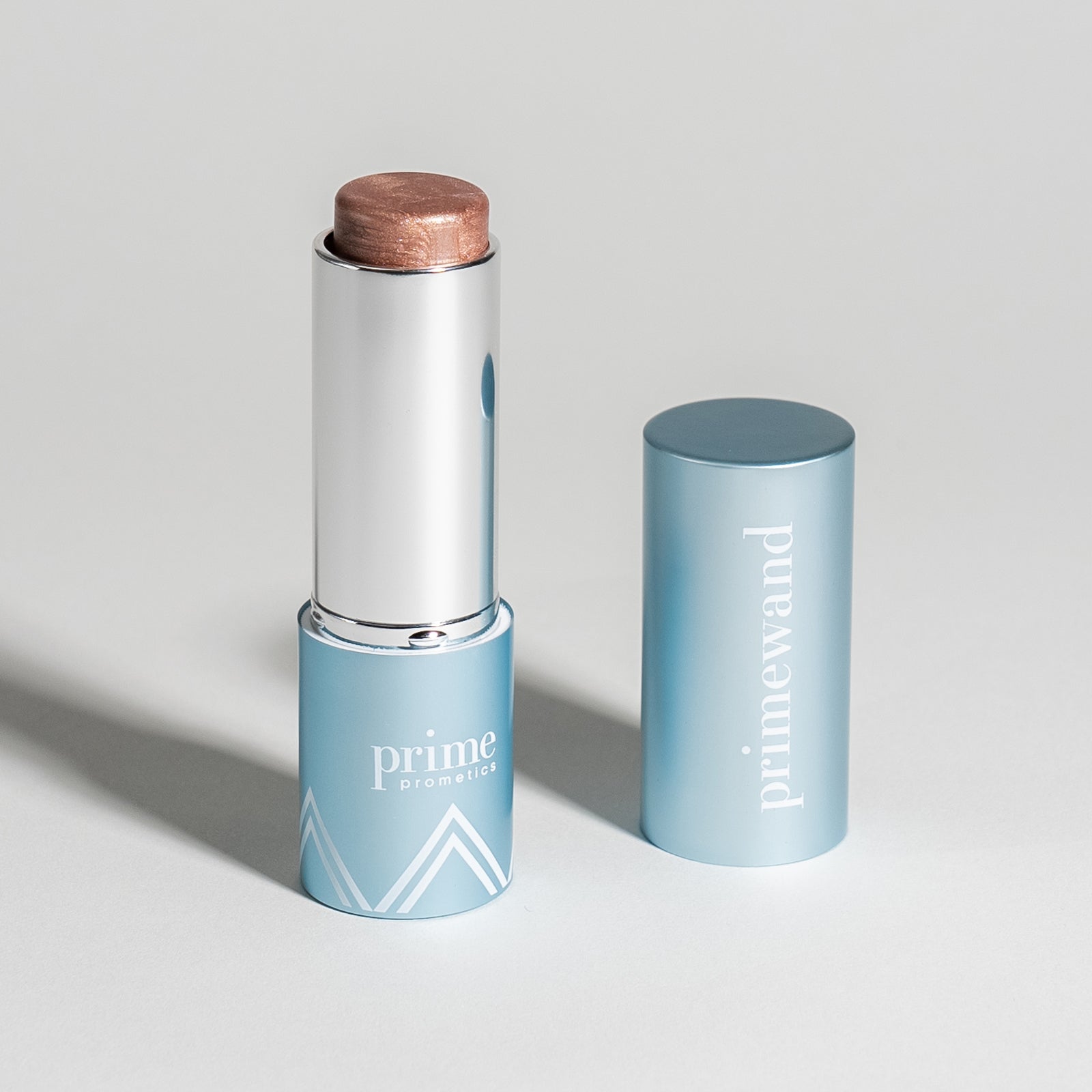 Prime Prometics PrimeWand Pearl highlighter stick with a shimmery champagne-bronze top and blue cap
