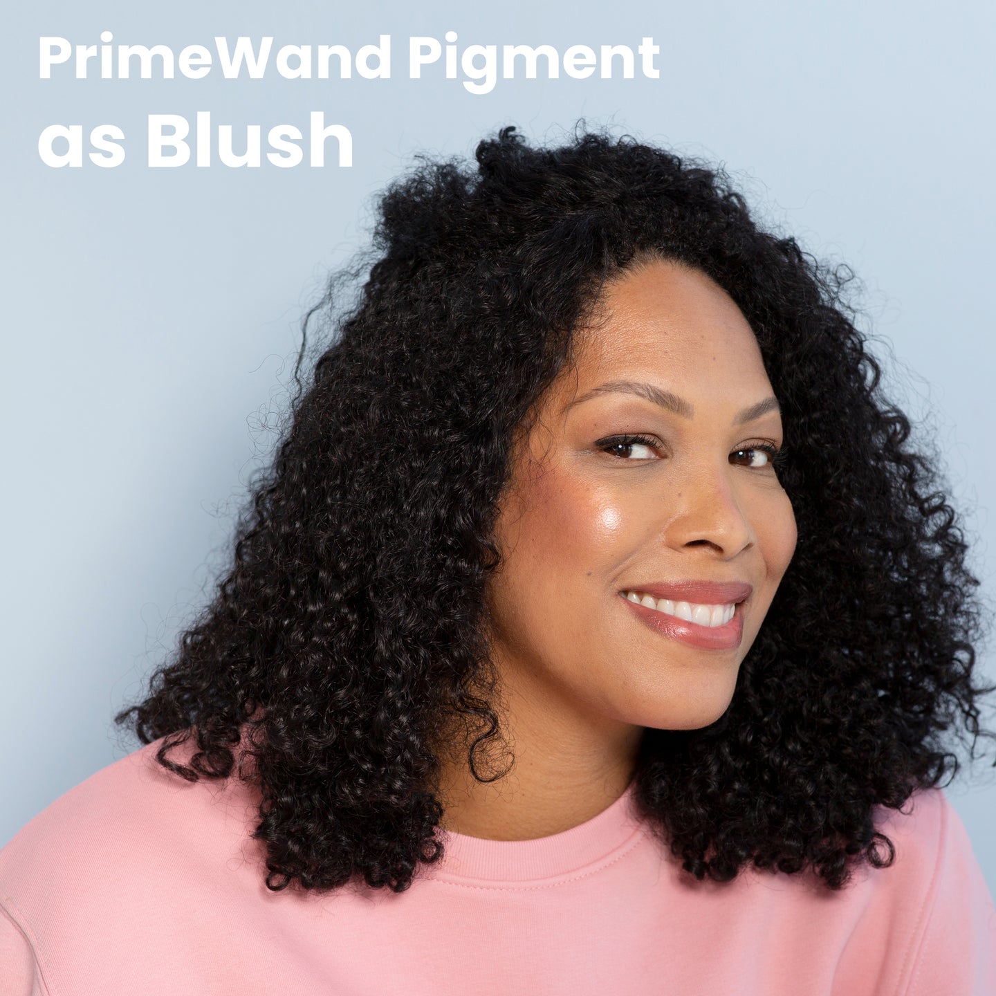PrimeWand Pigment as Blush: a mature woman with dark curly hair wearing Prime Prometics PrimeWand Pigment as a flush of color on her cheeks
