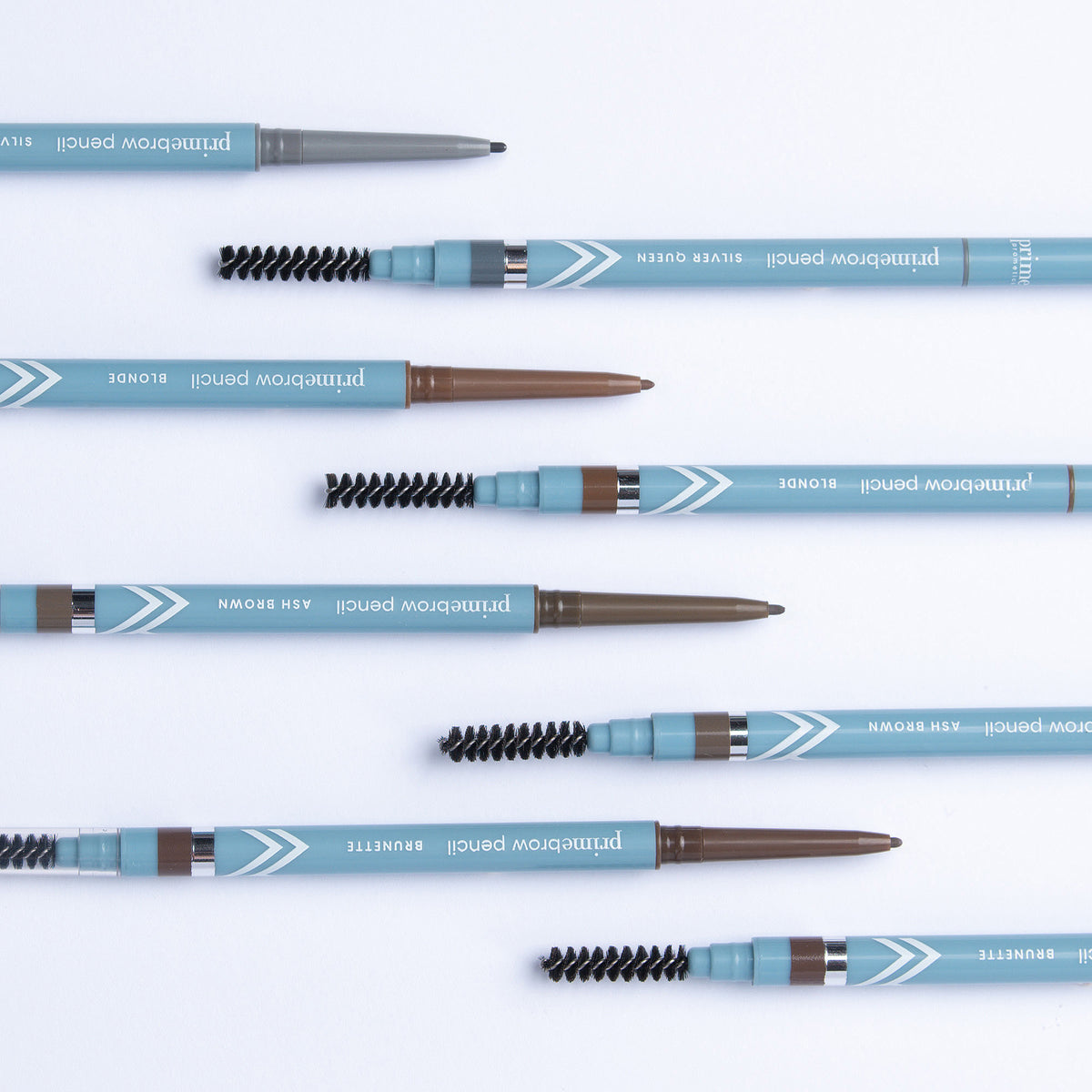 Nine blue eyebrow pencils with spoolie brushes, labeled in different shades (Blonde, Ash Brown, Brunette, Silver Queen, etc.), are arranged neatly on a white background.