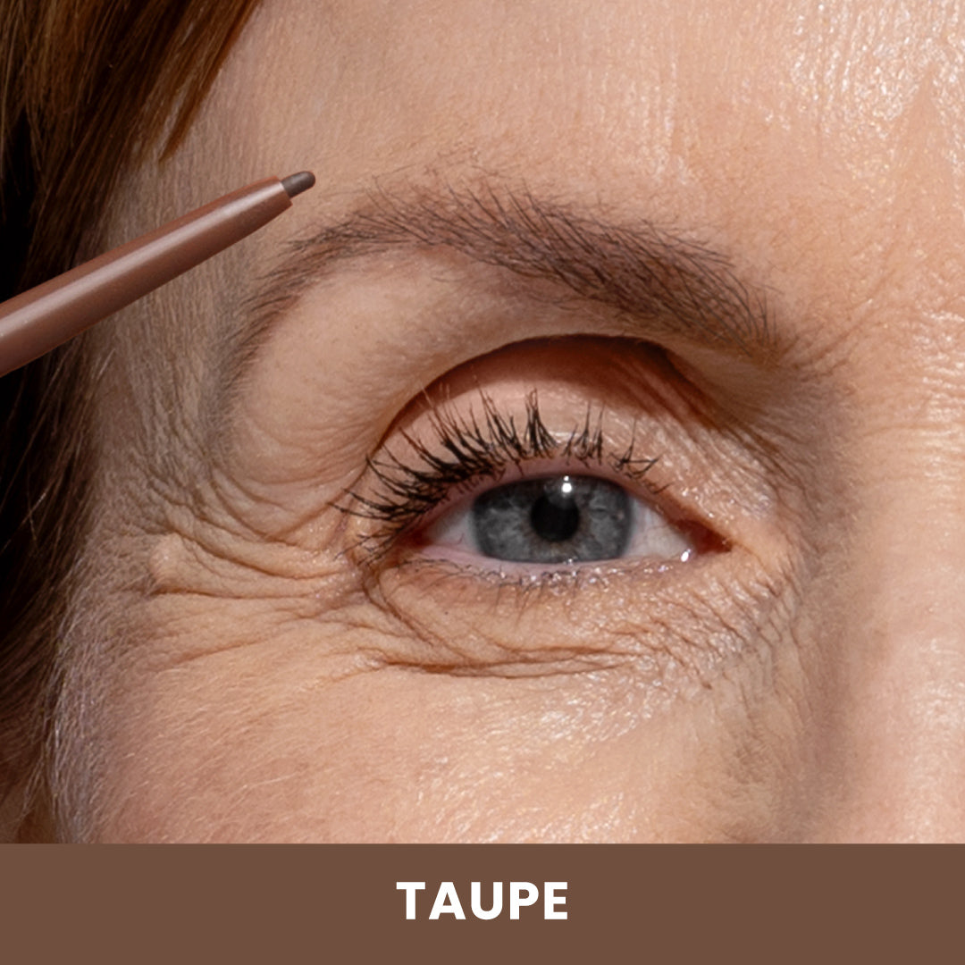 Close-up of a person using a taupe eyebrow pencil to fill in their eyebrow. The pencil is held near the brow, and the background below the image displays the word TAUPE in bold letters.