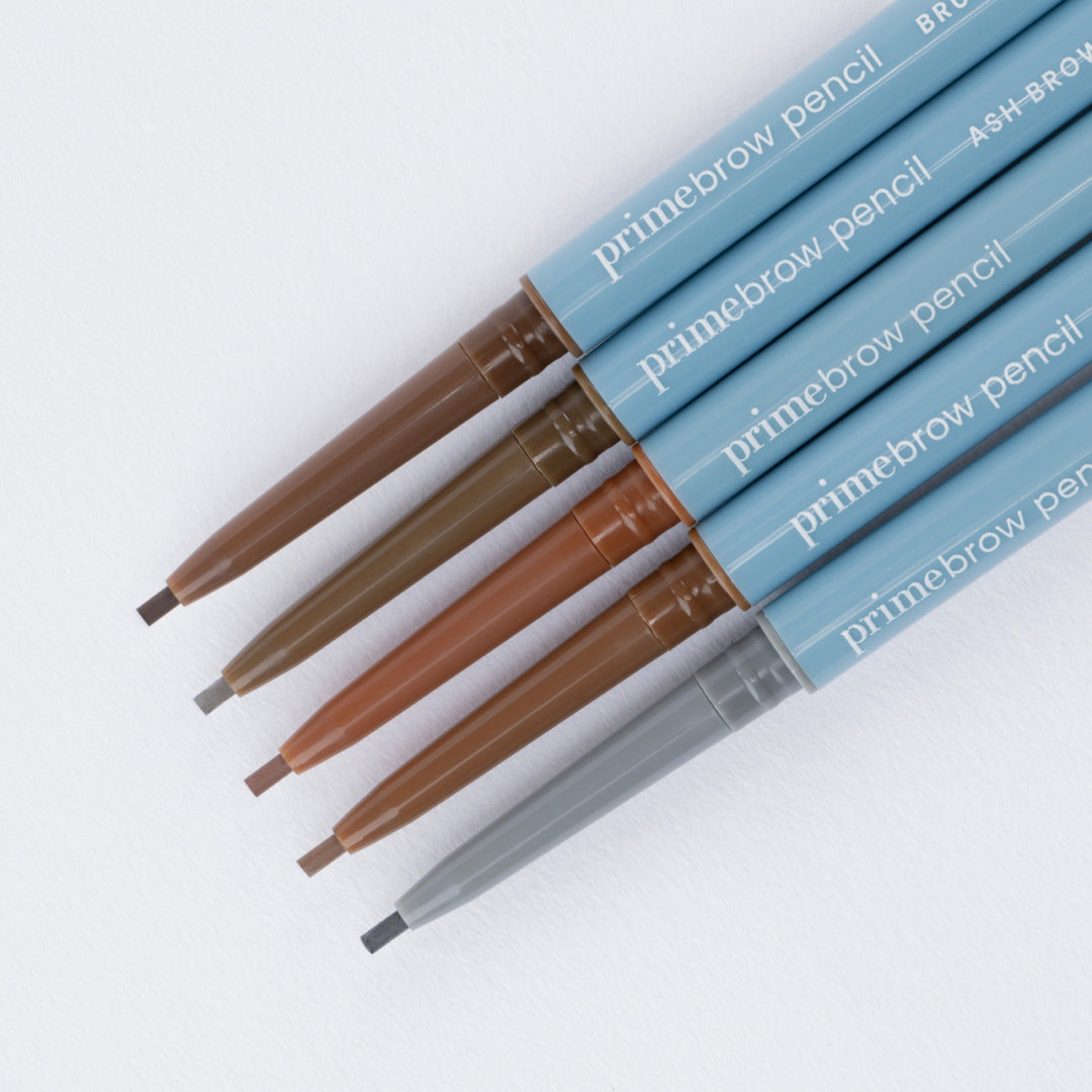 Five eyebrow pencils with blue casings are arranged diagonally on a white background, each with a different shade of brown or gray tip exposed. The pencils are labeled primebrow pencil.