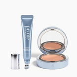 Eine Tube aus dem „PrimePrometics™ Undereye Rescue Duo“ ohne silberne Kappe liegt neben einer geöffneten Dose mit beigem Kompaktpuder und einem Spiegel, die beide in einer hellblauen Verpackung präsentiert werden – ideal, um Tränensäcke zu bekämpfen und ein erfrischtes Aussehen zu erzielen.
